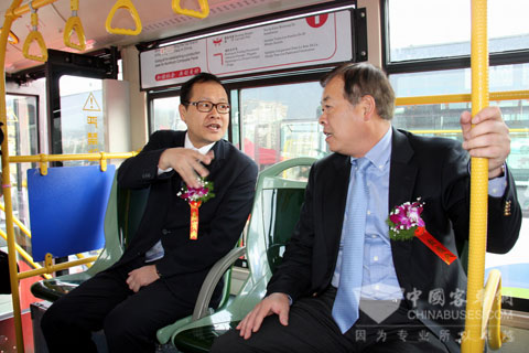 Xu Xiangdong, the deputy general manager of King Long Bus (left) introduces the development of King Long new energy buss to Ye Zhonggeng, vice mayor of Xiamen City (right)