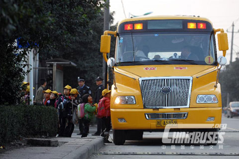 Primary school students queue up to get on the school bus to go home after school in Deqing County
