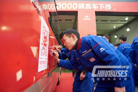 The staff representatives sign their names on the vehicle.